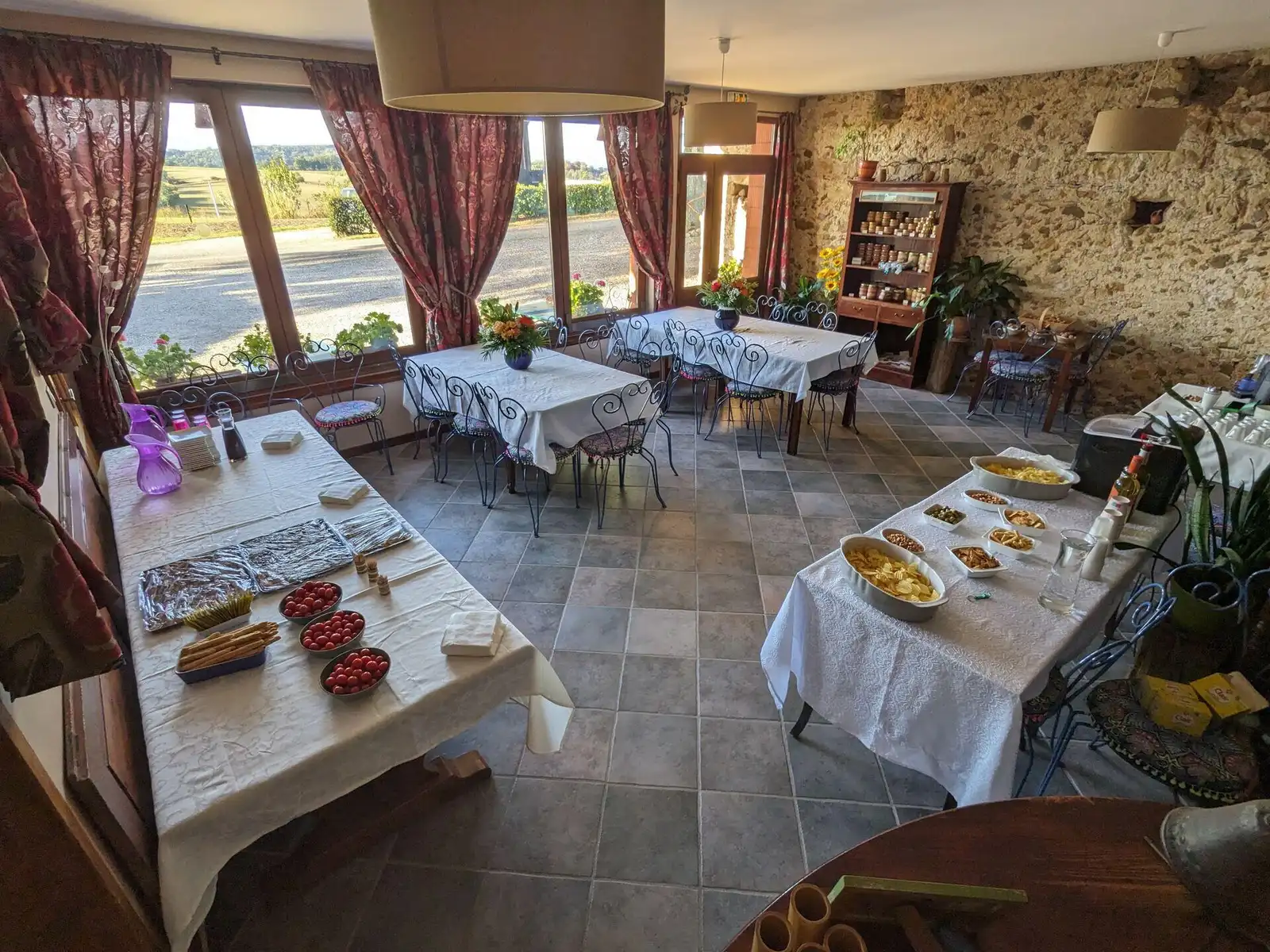 La salle en pierre de la ferme auberge, dressée pour recevoir des convives